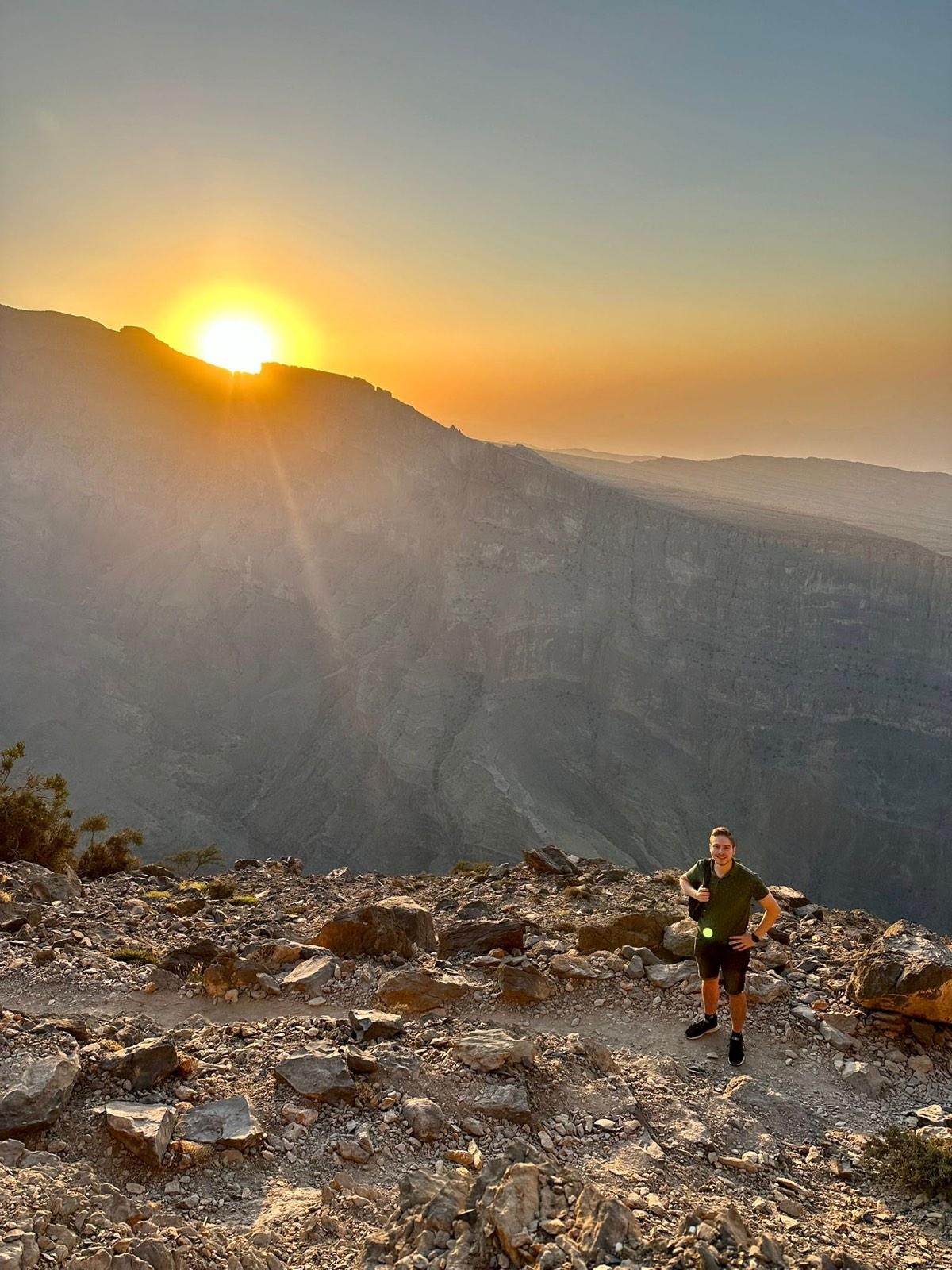 Wandelaar op de kloofrand bij laagstaande zon