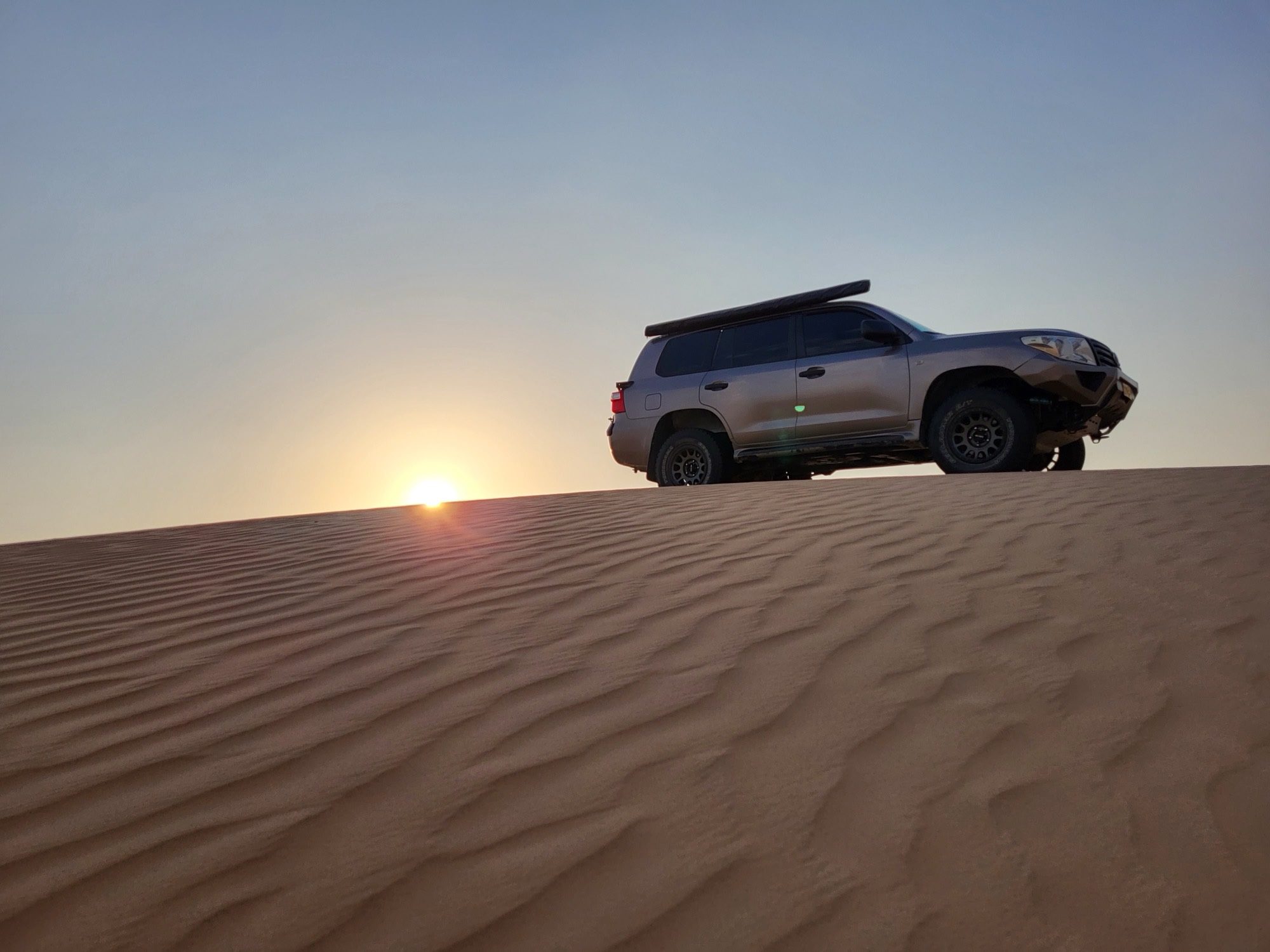 Met de 4x4 over de duinrand, vlak voor zonsondergang